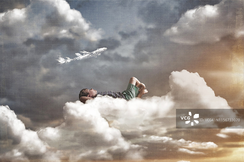 数字合成，一个孩子躺在一片大云上。你正在看一朵形状像飞机的云。图片素材
