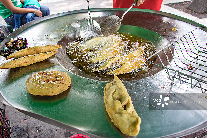 在墨西哥城阿拉米达中央公园的周末市场上，一名男子正在烹饪墨西哥食物。图片素材