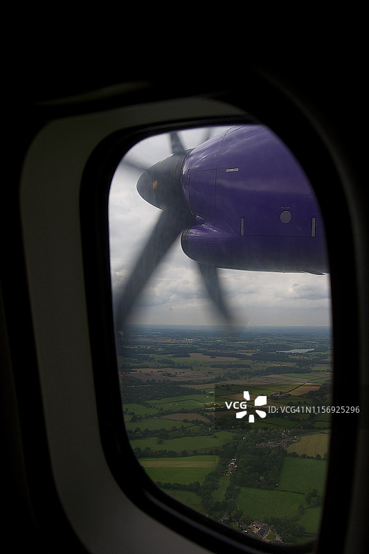 在飞行中的飞机窗外旋转的螺旋桨图片素材