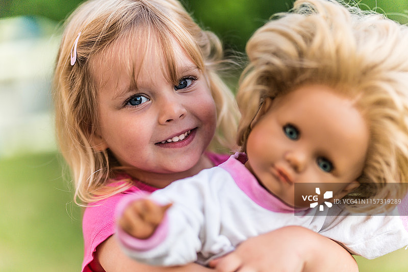 小女孩在户外玩洋娃娃图片素材