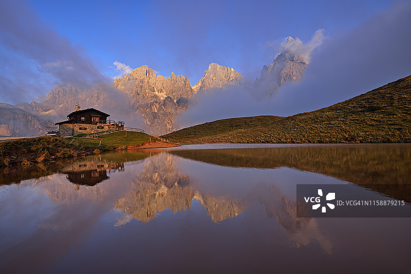 意大利，山群与帕莱迪圣马蒂诺山西门德拉帕拉反映在小湖日落，Rifugio Baita Giovanni Segantini图片素材