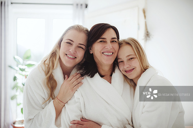 一个快乐成熟的女人和两个女儿在家里的浴室里图片素材