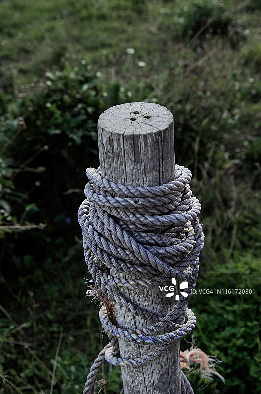 旧尼龙绳缠绕在一根木柱上图片素材