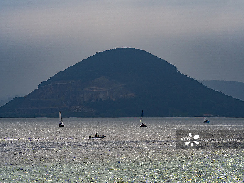 在坎特布里亚(西班牙)拉雷多和Santoña之间航行的船的海岸景观图片素材