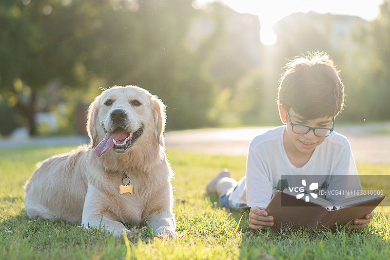一个男生和她的狗在看书图片素材