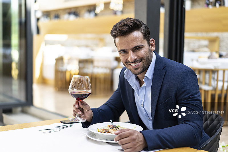 商人在餐厅用餐，喝红酒图片素材