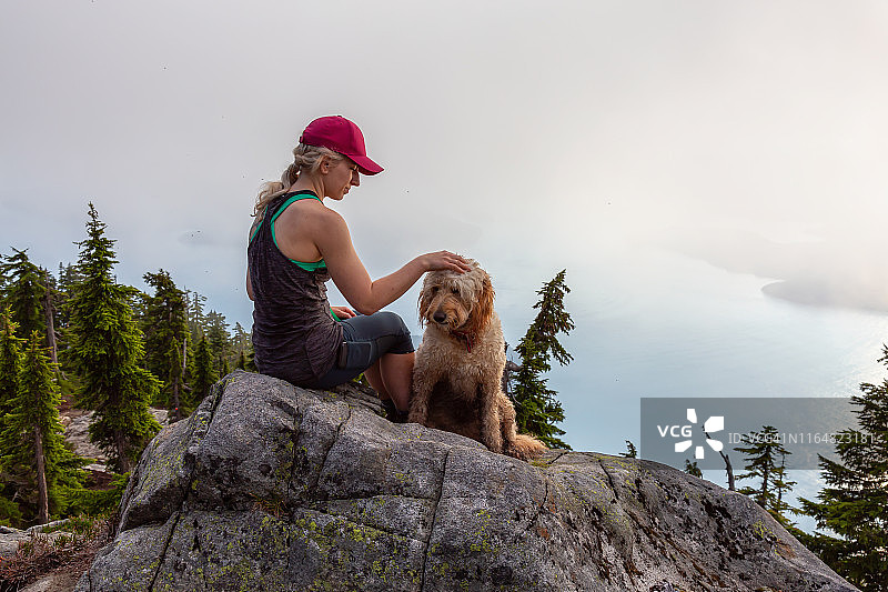 女孩和一只狗在山上徒步旅行图片素材