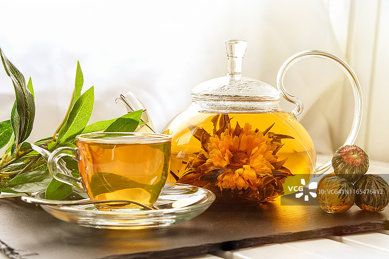 异国情调的绿茶与花在玻璃茶壶图片素材