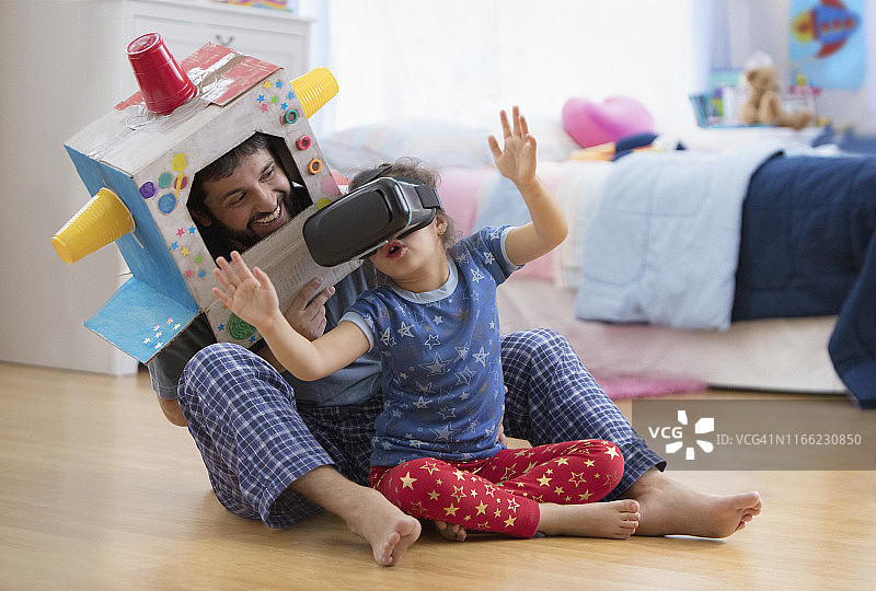 父亲和女儿使用虚拟现实头盔图片素材