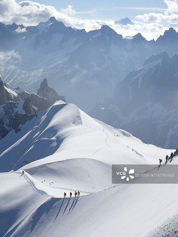 法国，高级萨沃伊，夏蒙尼，勃朗峰山脉，一些登山家徒步行走在雪山边缘的aiguille du midi图片素材