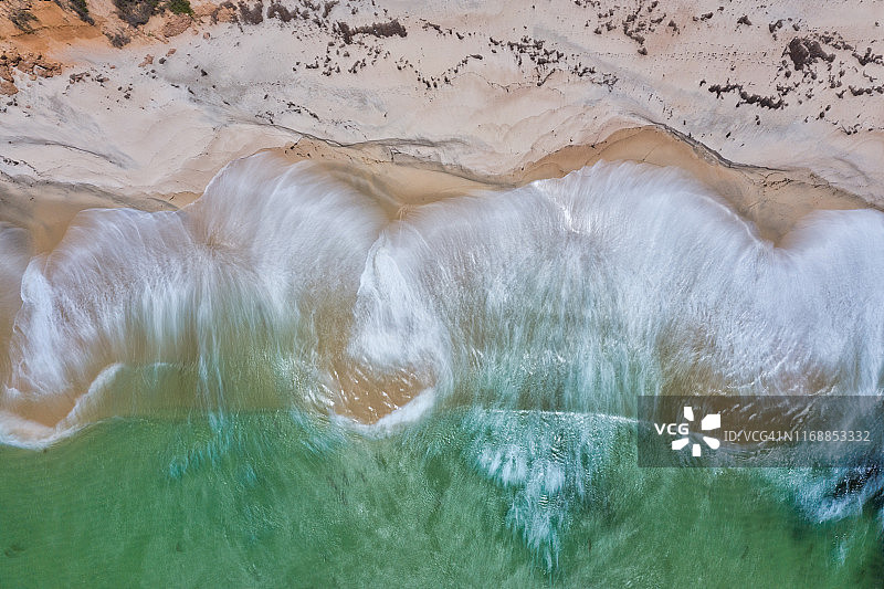 鸟瞰图的绿松石水撞击沙滩-长曝光图片素材