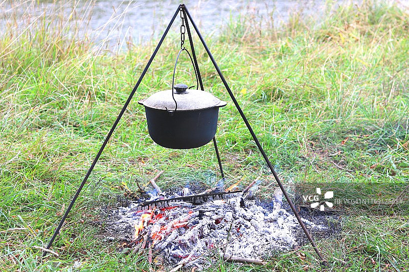 夏天在户外用铁锅在火上烹煮美味可口的食物图片素材