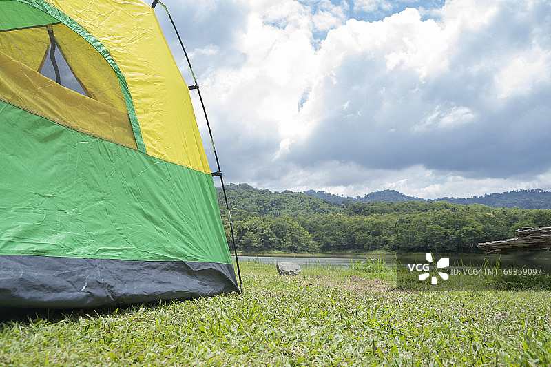 在湖边的森林里搭绿黄色的帐篷。图片素材