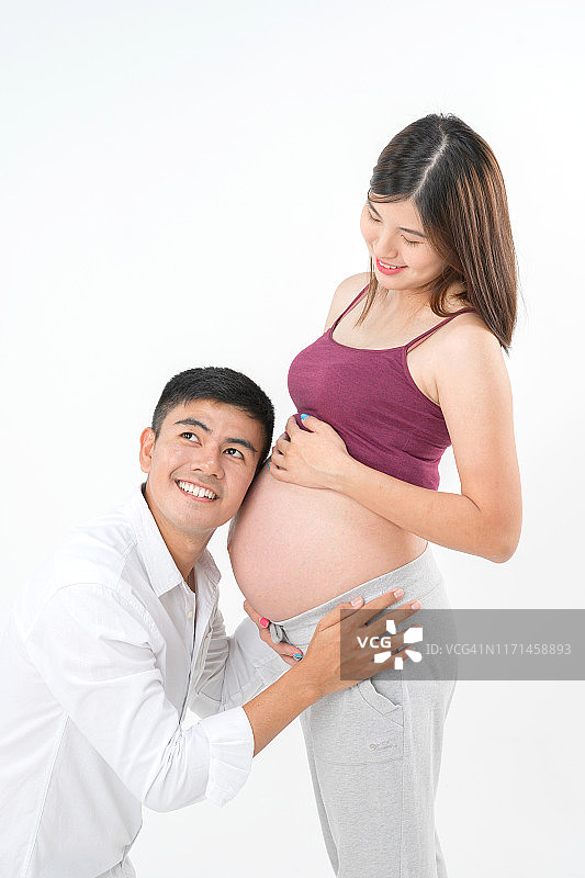 怀孕的概念。美丽的亚洲孕妇和她的丈夫听肚子他怀孕的妻子图片素材