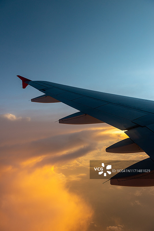 戏剧性和美丽的云景在日落的场景与机翼的飞机视图从飞机窗口图片素材