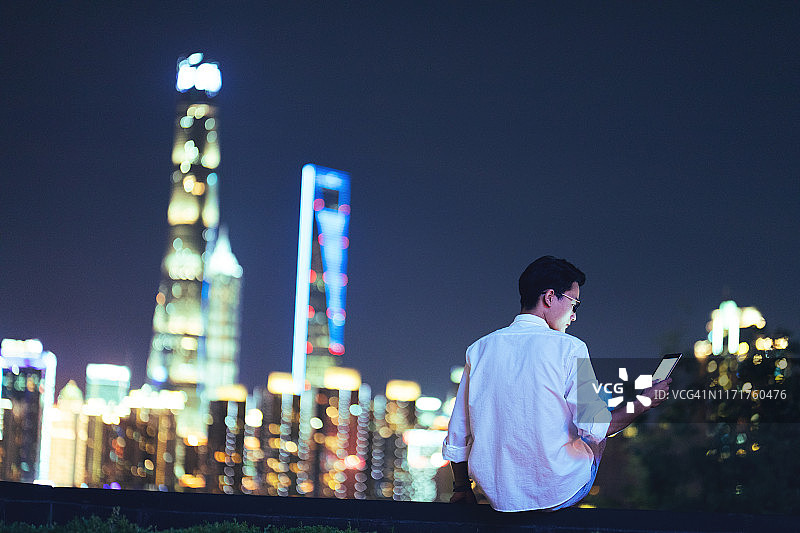 中国上海，年轻的亚洲商人正在使用数码平板电脑图片素材