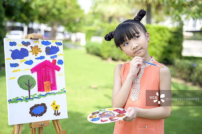 年轻有才华的女孩在画布上作画。获得绘画的灵感。图片素材