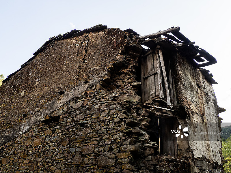 被遗弃的中世纪村庄，街道狭窄，废弃的房子用石头和石板建造，木门和窗户和毁坏的房屋。农村人口减少的概念图片素材