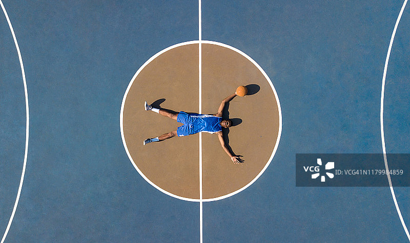 空中拍摄篮球运动员和球场上的球图片素材