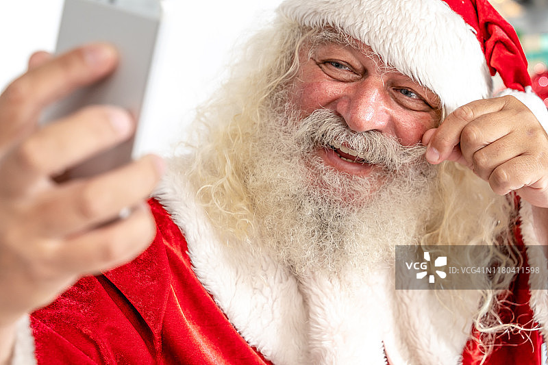 圣诞老人对着智能手机的摄像头微笑图片素材