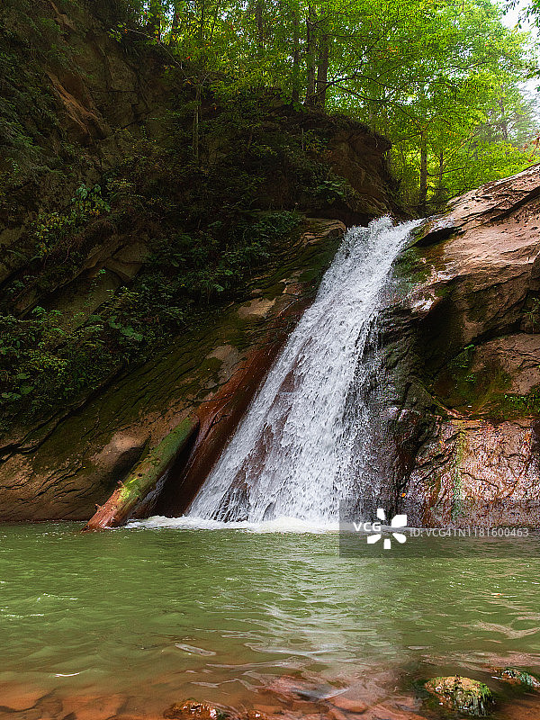 梦一般的瀑布隐藏在山在夏天的森林图片素材