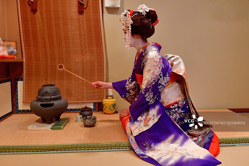 日本京都茶馆，一名身穿舞子服装的日本妇女在练习茶道图片素材