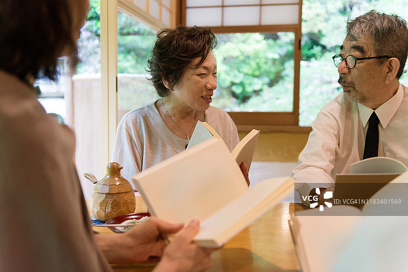 日本的成年人在京都一家咖啡馆的读书俱乐部里读书图片素材