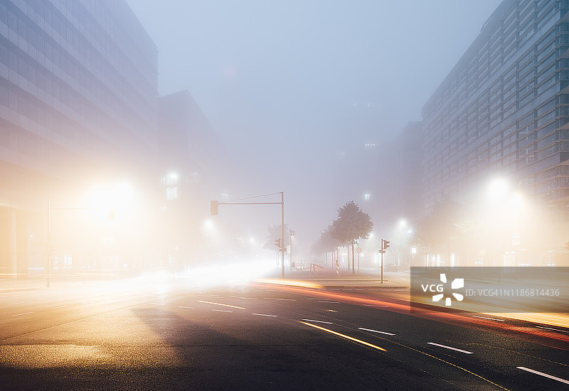 现代柏林波茨坦广场城市夜间天际线与交通和极端雾图片素材