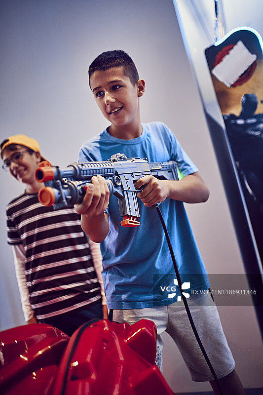 一个少年在游乐场用枪射击图片素材