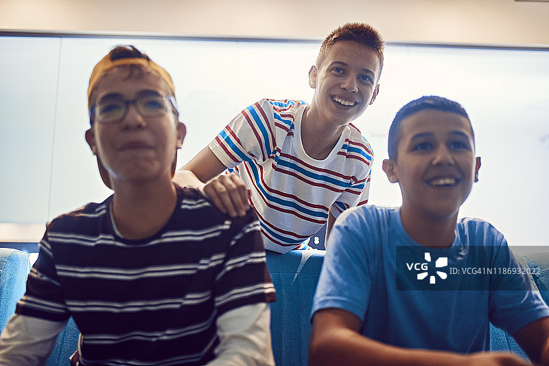 快乐的青少年朋友在游乐场玩电子游戏的肖像图片素材