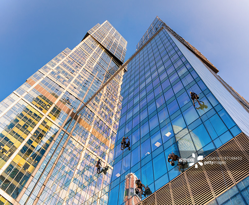 攀登者在擦洗摩天大楼的窗户——“首都之城”。图片素材