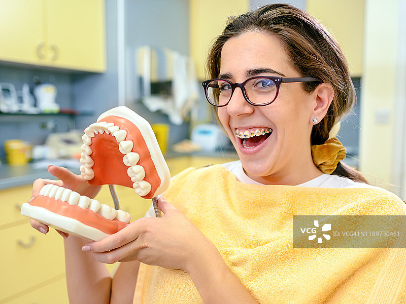牙医病人微笑着戴着塑料假牙图片素材