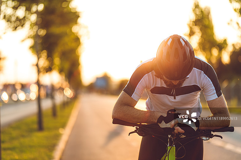 骑自行车的人在日落大道上图片素材
