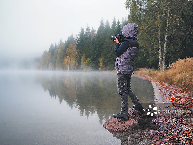创意儿童，儿童摄影师(一个小男孩)带着相机在拉湖附近拍摄风景照片图片素材
