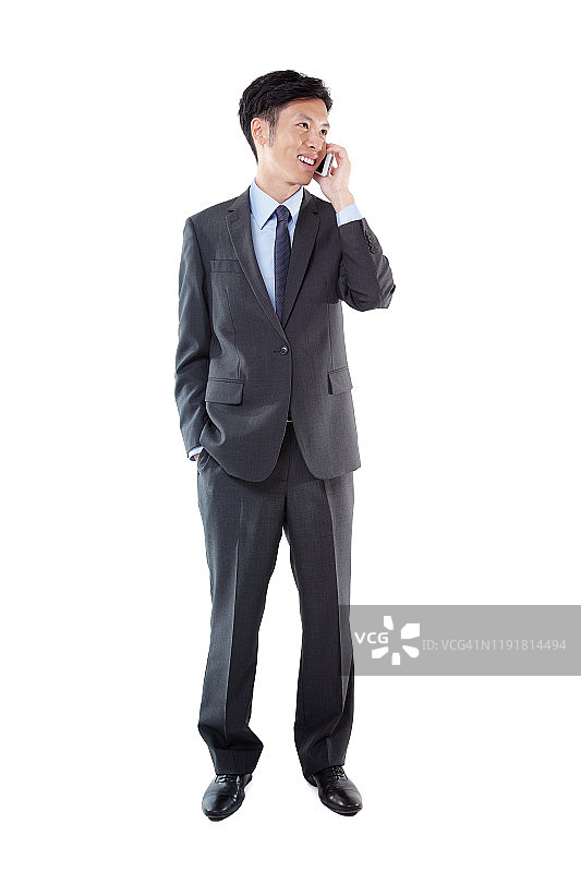 年轻的亚洲商人在白色背景下用快乐的情感打电话图片素材