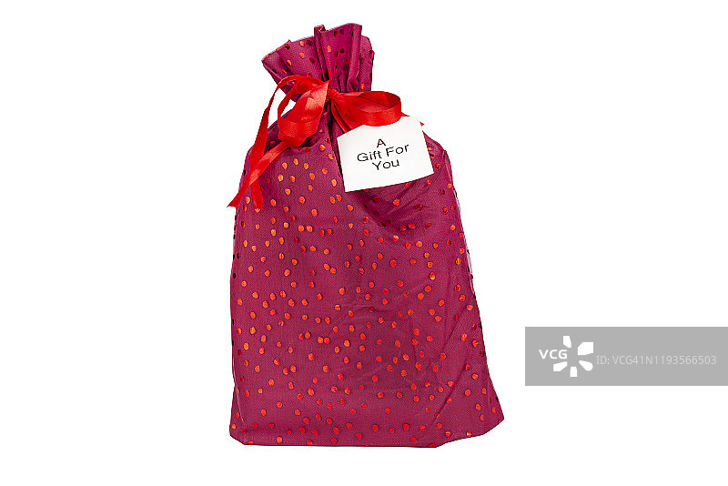 一件用紫红色布料和丝带包裹的圣诞礼物，在一张纸上写着“送给你的礼物”，孤立在一个白色的背景与剪报路径。图片素材