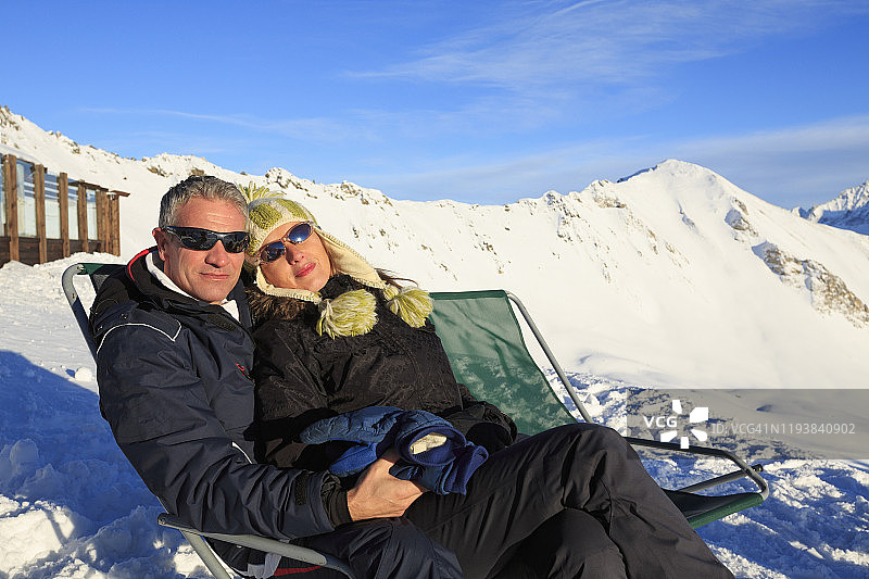 业余冬季运动高山滑雪。朋友女人和男人滑雪者享受在阳光明媚的滑雪场。高山雪景。阿尔卑斯山，欧洲，意大利。图片素材