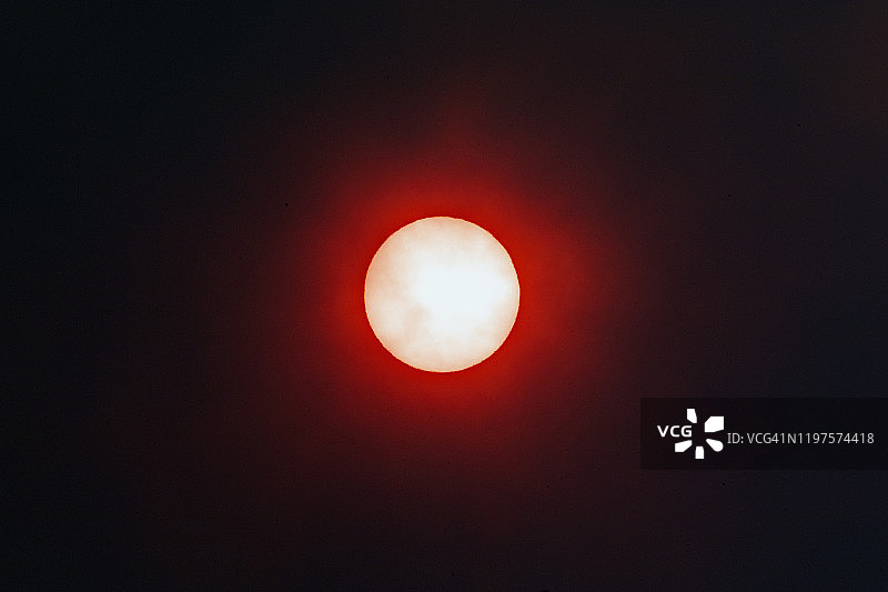 近距离的太阳透过烟雾从丛林火与红色辉光，气候变化在澳大利亚图片素材