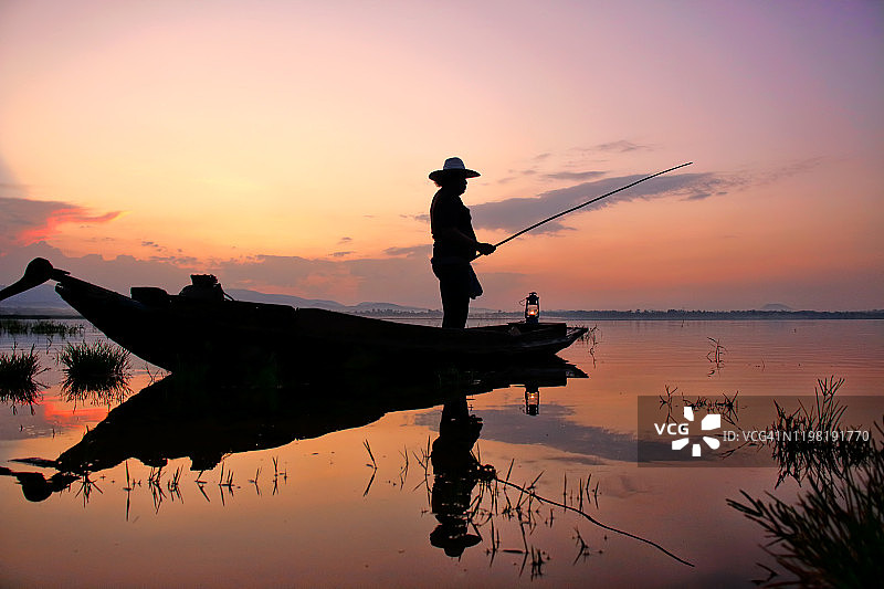 亚洲渔民在湖上的木船和鱼竿图片素材