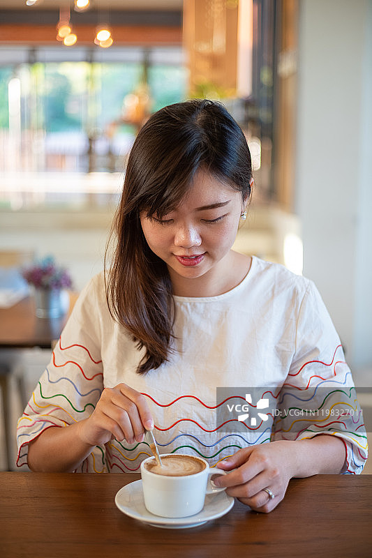 年轻的亚洲女性正在咖啡厅喝咖啡休息图片素材