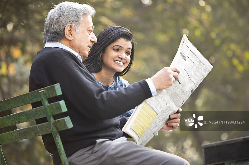 爸爸和女儿在公园看报纸图片素材