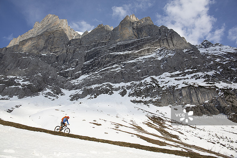 男性山地自行车下山雪坡图片素材
