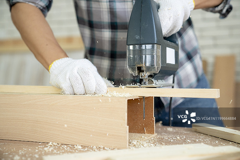 手工木工用电锯切割木板。DIY工艺制作理念图片素材