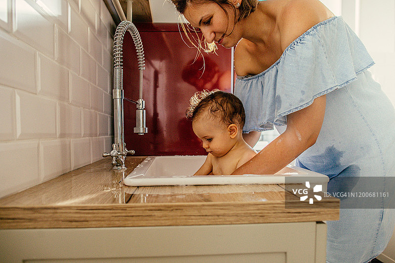 在厨房水槽里给婴儿洗澡图片素材