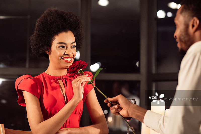 丈夫送红玫瑰给妻子在餐厅庆祝情人节图片素材