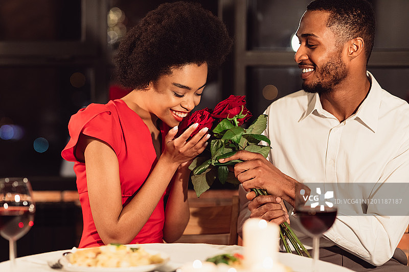 有爱的男朋友给女朋友捧花，约会在餐厅吃饭图片素材