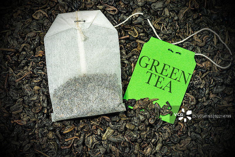 许多干茶叶上的绿茶袋的特写-火药茶图片素材