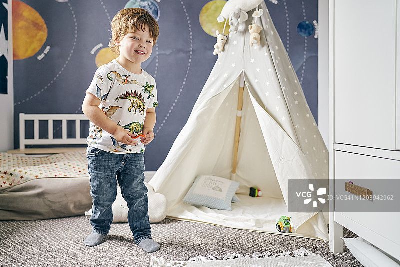 孩子在房间里玩耍，孩子的帐篷，墙上的太阳系壁画图片素材