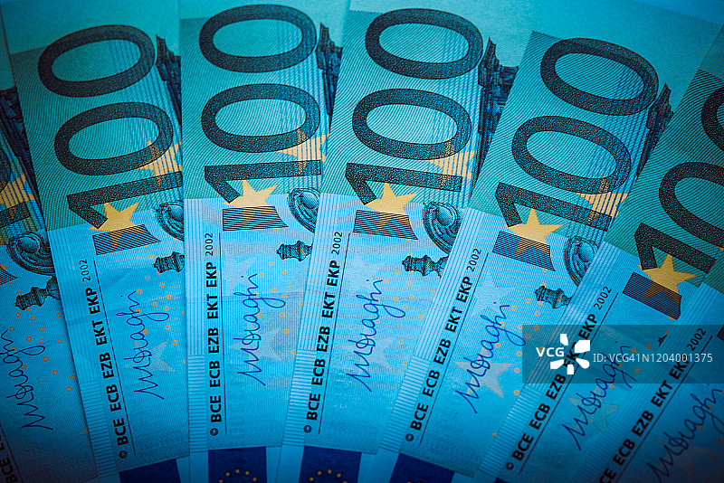 欧元的钱。欧元现金的背景。欧元纸币。风格的蓝色的光。图片素材