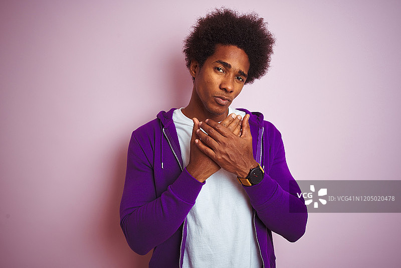 年轻的非洲裔美国人穿着紫色的运动衫站在孤立的粉红色背景上手和手指疼痛，关节炎图片素材